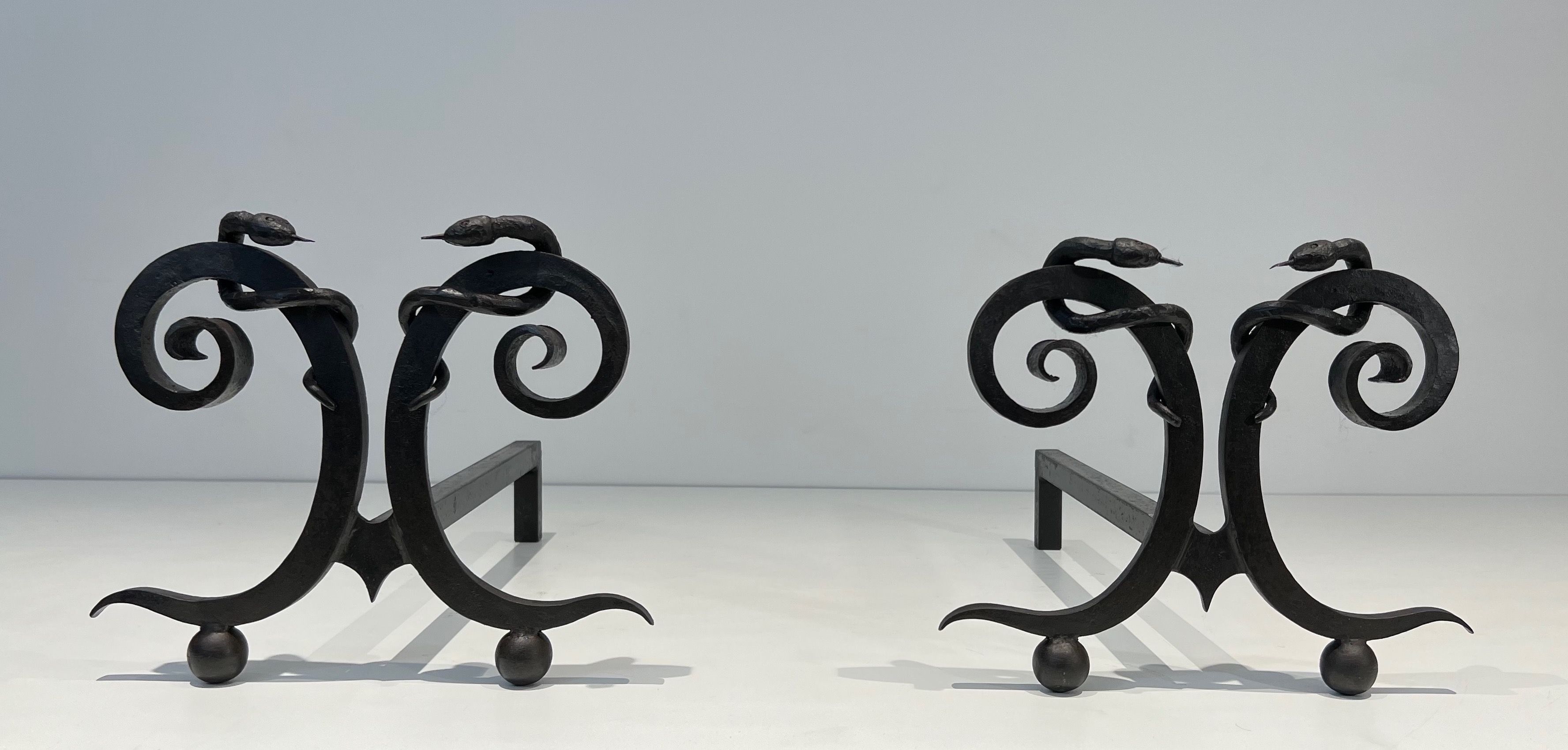 Pair of Wrought Iron Andirons with "Snakes" in the style of Edgar Brandt