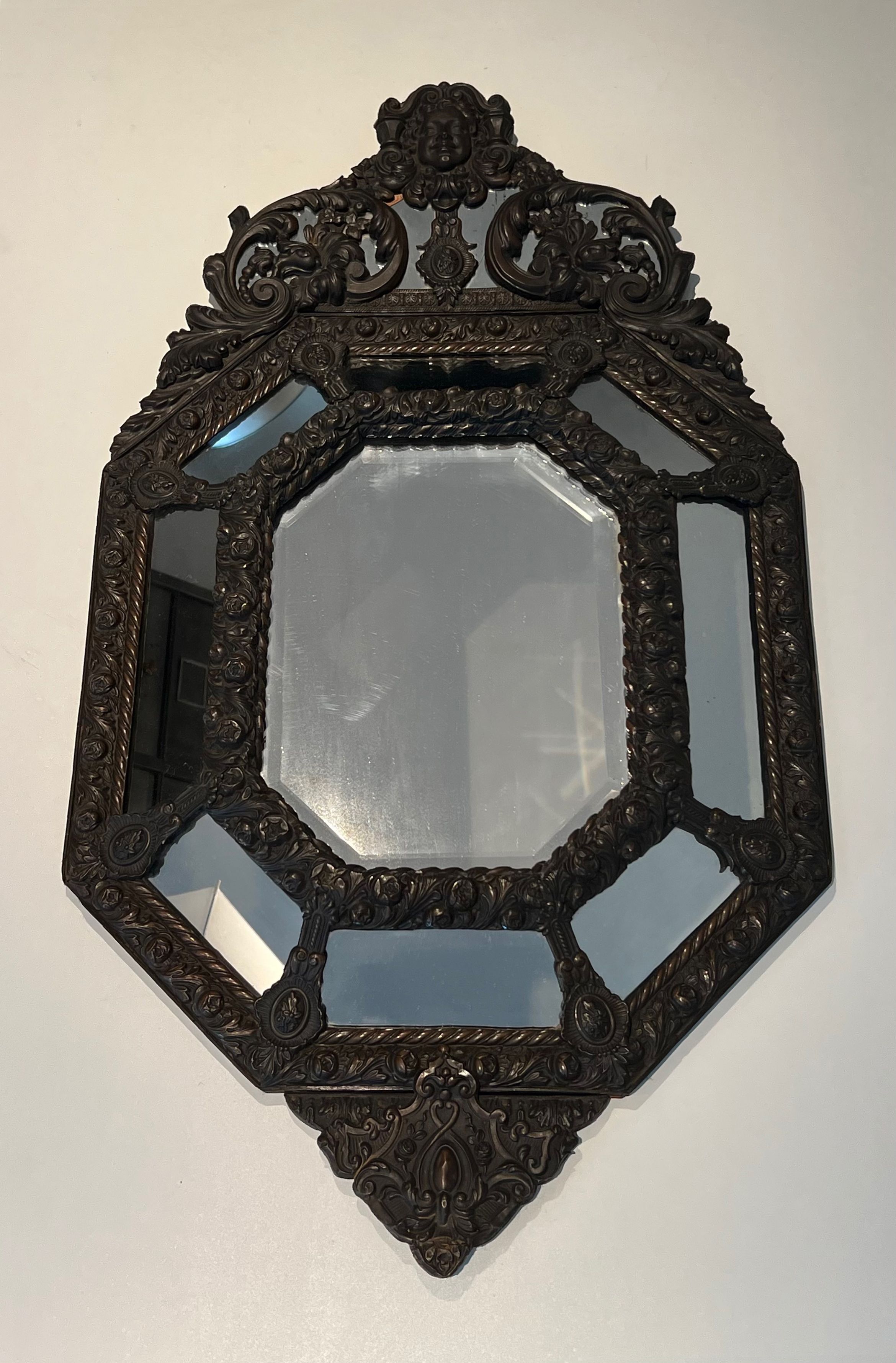 Miroir à Pare-closes en cuivre Repoussé à Décors de Guirlandes de Fleurs et Surmonté de l'Effigie du Roi Soleil