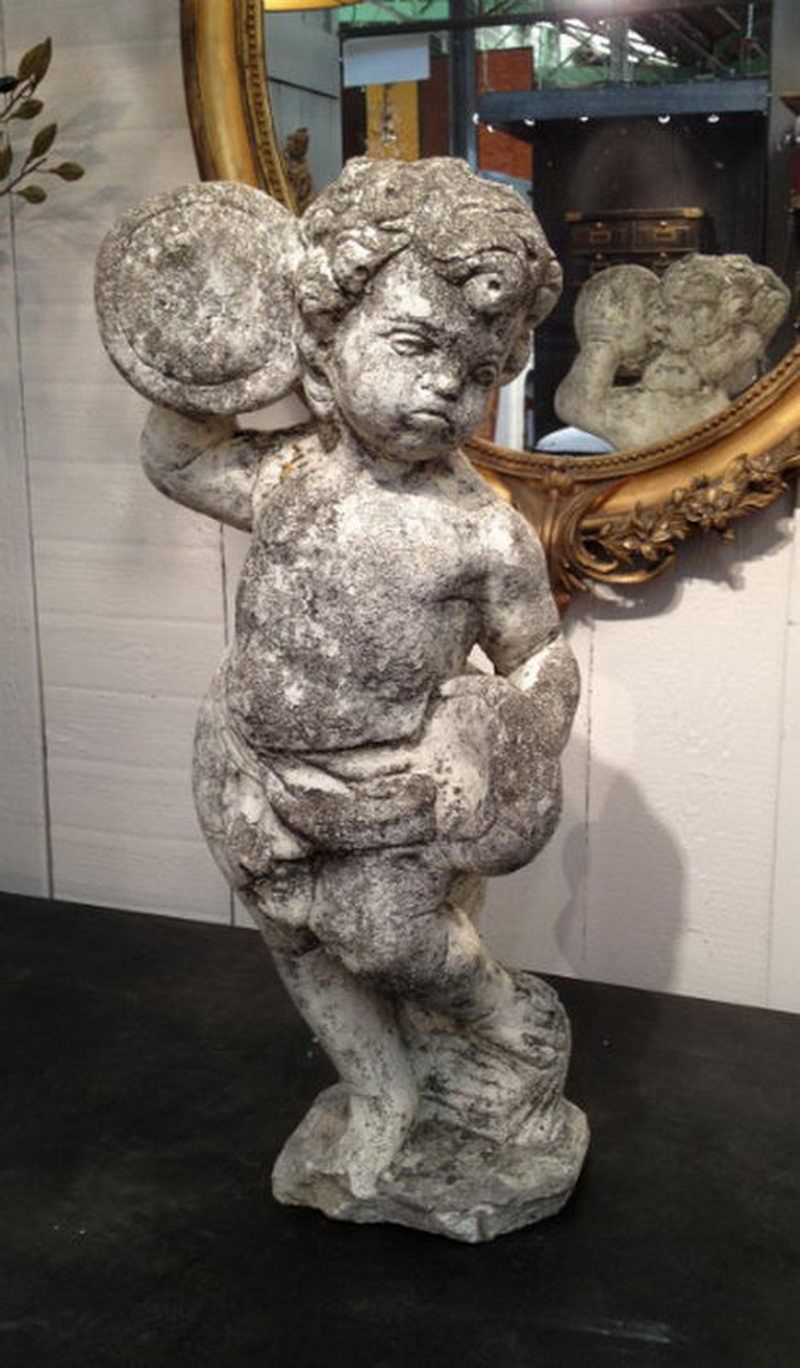 "Cherub playing drum" cement figure.