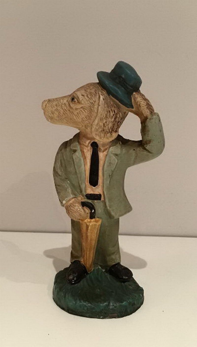 Anthropomorphic plaster figure representing a dog with hat and umbrella