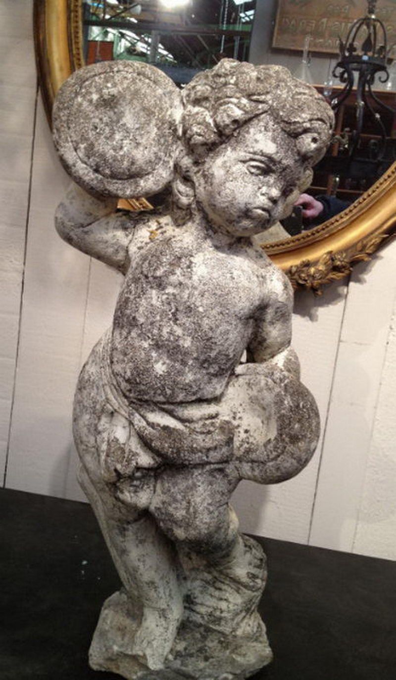 "Putti jouant du tambourin" en ciment.